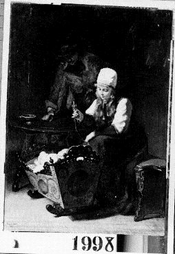 Familiegeluk - Jonge boerin met lichtblond loshangend haar onder witte muts, zittend bij een wieg, 1878, Kate Bisschop-Swift